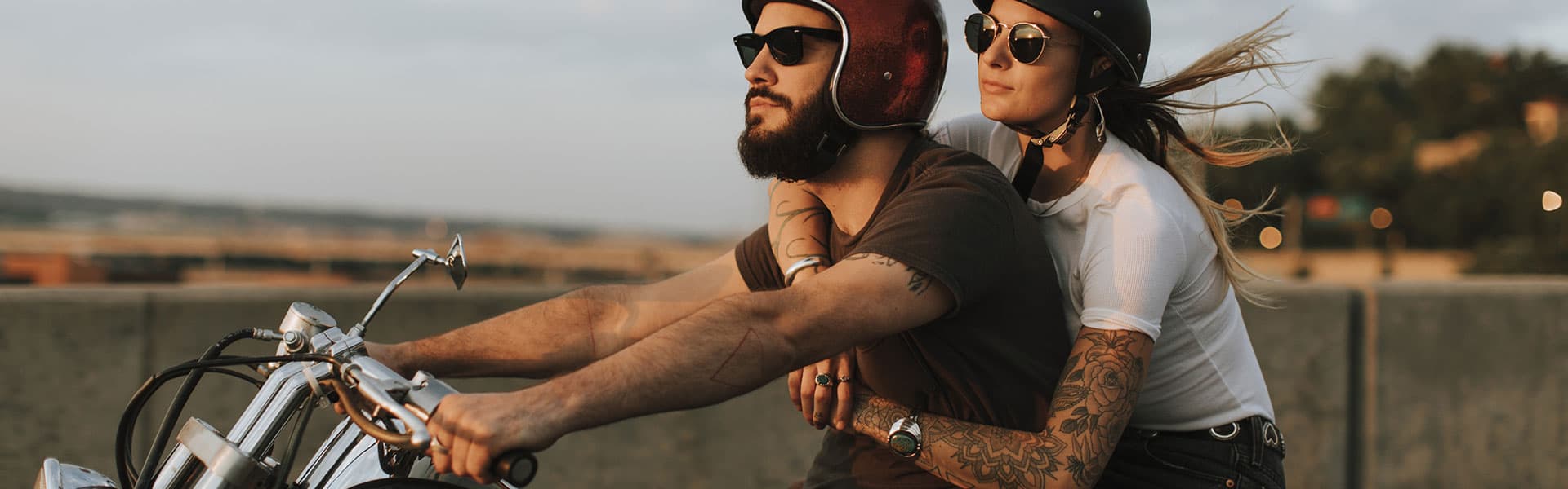 Couple riding a motorcycle powered by Yuasa batteries