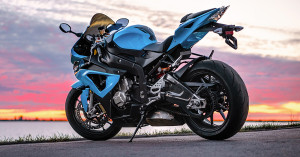 Blue motorcycle in front of the sunset.