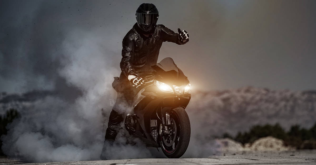 Rider on his bike giving a thumbs up after finding the best battery for BMW bikes.