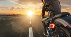 Solo rider on bike rides into the sunset