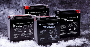 Yuasa batteries for snowmobiles on a snowy backdrop. 