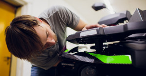 Man checks his powersports vehicle in his garage during winter storage.