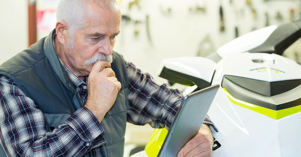 Man looks at tablet to check on storage for his jetski.