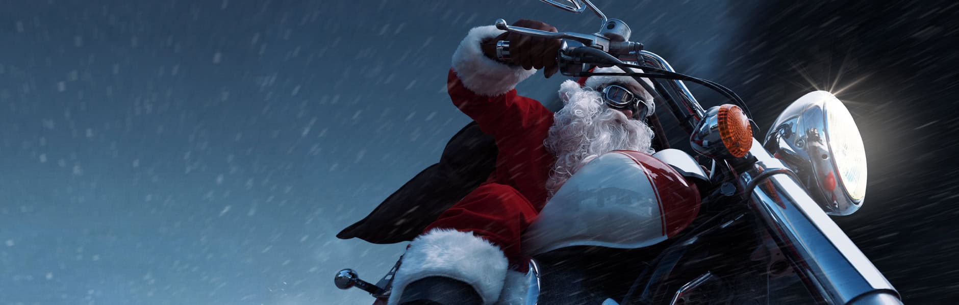 Santa on a motorcycle with gifts for powersports enthusiasts.
