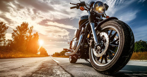 Bike sits in the sunset on an empty road. 