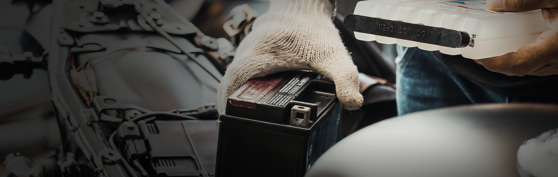 Rider learning how to maintain their battery, wearing white gloves.