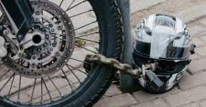 Chain lock around a motorcycle tire and pole. 